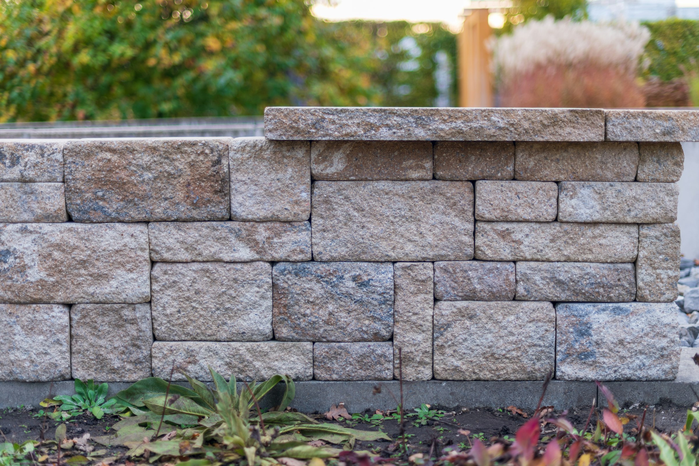 Segmental block garden retaining wall with a cap course